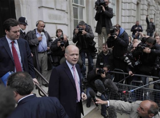 Conservative shadow Foreign Secretary William Hague, center, talks to members of the media as George Osborne, left, shadow finance minister, looks on as they arrive for their meeting with representatives of the Liberal Democrats on Sunday in London.